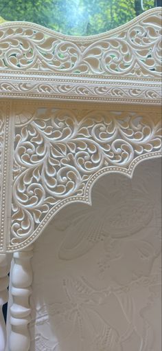 an intricately carved table with white paint on it