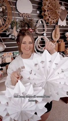 a woman is holding up some paper stars