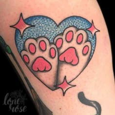 a heart shaped tattoo with paw prints and stars