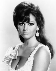 an old black and white photo of a woman in a dress with large earrings on her head