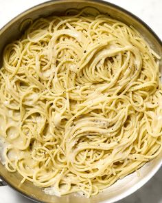 a pot filled with pasta and sauce on top of a table