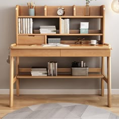 a wooden desk with books and other items on top of it in front of a gray wall