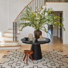 a vase with yellow flowers sitting on top of a table next to a stair case