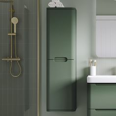 a bathroom with green walls and tile flooring next to a sink, shower head, and mirror