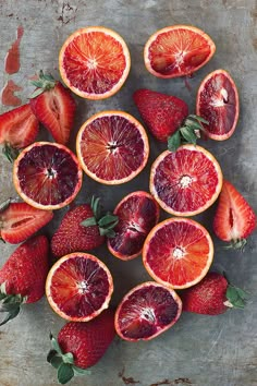 sliced blood oranges and strawberries on a table