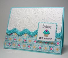 a happy birthday card with a cupcake on the front and blue trimmings