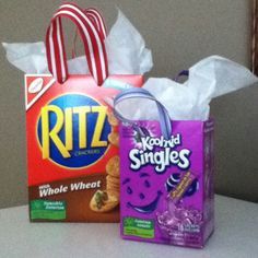 two shopping bags sitting next to each other on top of a white table with tissue paper