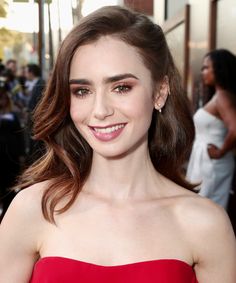 a woman in a red dress smiling at the camera