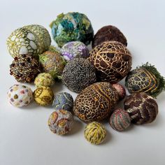 an assortment of different colored balls on a white surface