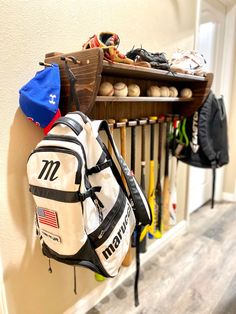 a rack filled with baseball equipment next to a wooden shelf holding sports gear and balls