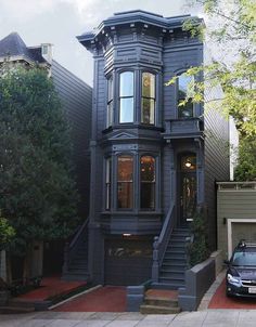 a car parked in front of a house with stairs leading up to the top floor