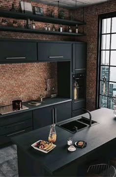 a modern kitchen with black cabinets and an island in front of a window overlooking the city