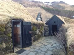 an outhouse in the middle of nowhere with grass growing on it's roof