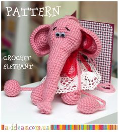 an elephant made out of crochet sits on top of a table next to a greeting card