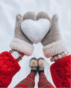 two hands in mittens holding a white heart