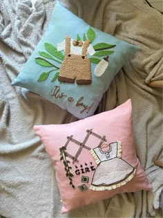 two decorative pillows on top of a bed next to a pillow that says kiss a boy