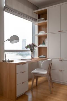 a chair and desk in front of a window with the city skyline seen through it