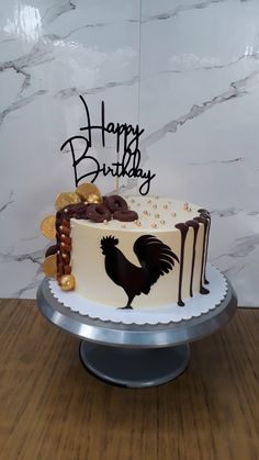 a birthday cake decorated with chocolate and cookies on a table in front of a marble wall