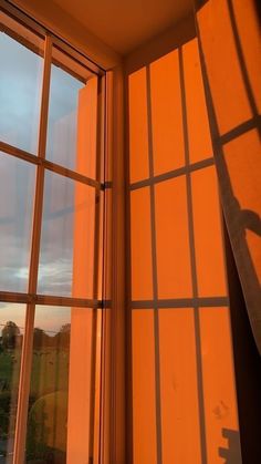 the shadow of a person standing on a window sill in front of an orange wall