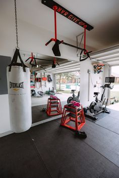 an indoor gym with exercise equipment and punching bag