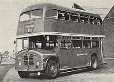 an old double decker bus parked in front of a building