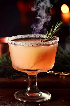 a drink sitting on top of a wooden table next to a lit candle and christmas decorations