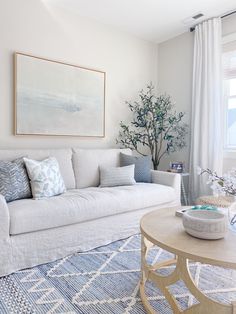 a living room filled with furniture and a large painting on the wall above the couch