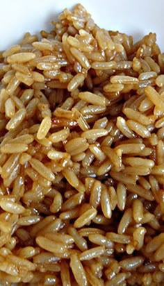 a white bowl filled with brown rice on top of a table