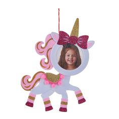 a pink and gold unicorn ornament hanging from a string