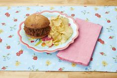 a plate with a hamburger and chips on it