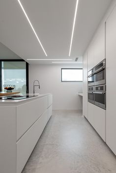 an empty kitchen with white cabinets and counter tops