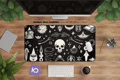 a computer desk with a keyboard, mouse and various items on it that include an image of a skull