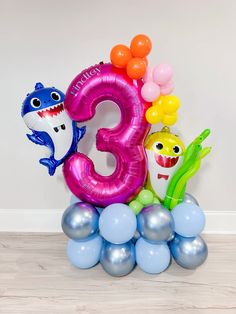 the number three balloons are placed on top of each other in front of a white wall