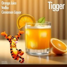 an orange juice is next to a glass with a tiger on it and another orange in the background