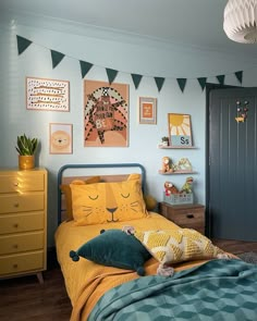 a child's bedroom decorated in blue and yellow with pictures on the wall above the bed