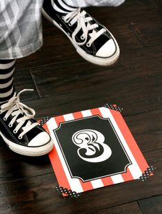 a pair of shoes standing on top of a wooden floor next to a door mat