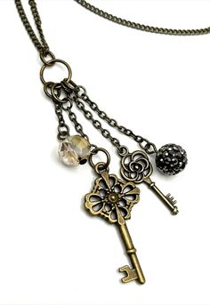 a necklace with an antique key and charms on it