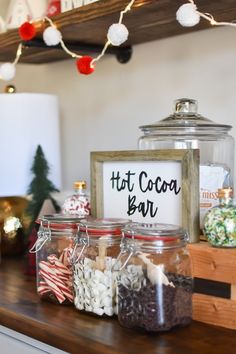 jars filled with candy and marshmallows sit on a counter in front of a christmas tree