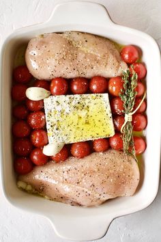 chicken and tomatoes in a white casserole dish