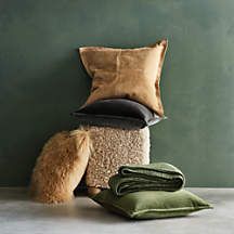 a pile of pillows and blankets sitting on top of a floor next to a green wall