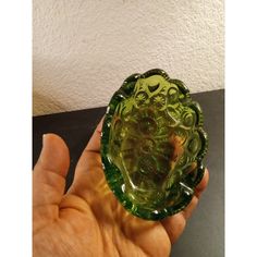 a person holding a green glass object in their hand