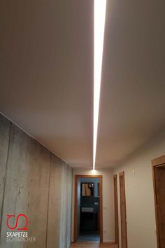 an empty hallway with light coming from the ceiling