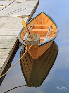 a small wooden boat tied to a dock