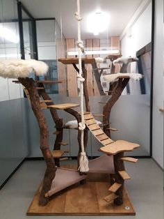 a tree house made out of wood and rope with white feathers on the top floor