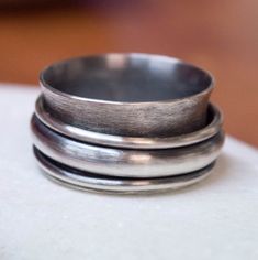 International deliveries in 2-4 business days as standard shipping. Totally handmade from 925 solid sterling silver. A rustic sterling silver ring with a big wide band and three silver spinners. Two of them are made by 1.5 mm sterling silver wire and the third by half-round wire 4mm in width and 2 mm thick. A rustic men's ring! It comes gift wrapped and ready for giving! ✿REGISTERED MAIL WITH TRACKING NUMBER ✿All of our jewelry are made to order. Allow for about a week for the jewelry to be made Silver Stackable Jewelry, Rustic Mens Rings, Jewelry Chunky, Rustic Rings, Wide Band Ring, Mens Gold Rings, Meditation Rings, Men Ring, Spinner Ring