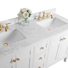 two white sinks sitting next to each other on top of a marble countertop with gold accents