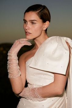 a woman in a white dress and gloves