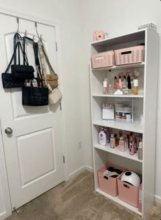 a white book shelf filled with lots of personal care items next to a pink purse