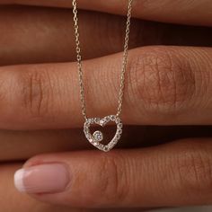 This 14K Gold Open Heart Necklace with CZ Pave is a beautiful and versatile piece, perfect for any occasion. Its minimalist design and sparkling cubic zirconia accents make it suitable for both daily wear and special events. Ideal as a birthday gift or a present for a bride, this necklace symbolizes love and affection. Pair it with matching jewelry for a coordinated look. Its quality craftsmanship and timeless design ensure it will be cherished for years to come. Product Features: * Made to Order: Crafted specifically to your preferences. * Gold KT: 14K Solid Gold (not filled, not gold vermeil, not plated) * Gold Color Options: Choose from Yellow, Rose, or White Gold, tailoring the necklace to your preferred style. * Gemstone: Adorned with a dazzling Cubic Zirconia, adding a touch of brill Wedding Heart Necklace, Wedding Heart Necklace With Diamond Accents For Valentine's Day, Valentine's Day Wedding Heart Necklace With Diamond Accents, Diamond Heart Cut Birthstone Necklaces, Diamond White Heart Pendant Necklace For Wedding, Diamond Heart Cut Birthstone Necklace, Dazzling Heart-shaped Wedding Necklace, Dazzling Heart Wedding Necklace, Wedding Necklace With Heart Charm And Cubic Zirconia