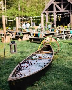 a row boat sitting on top of a lush green field